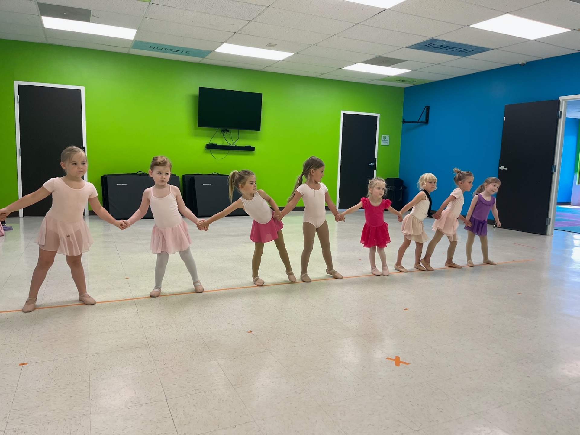 Young ballerinas holding hands in line