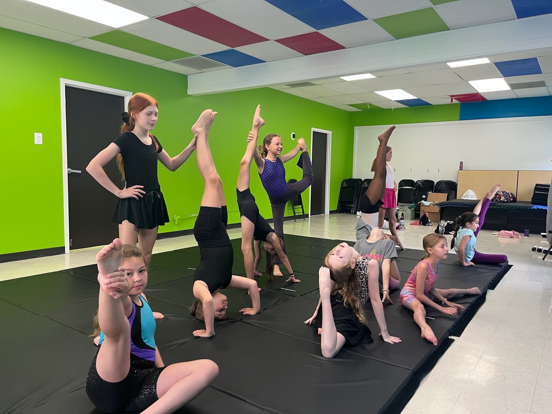 Dancers stretching and practicing on mats